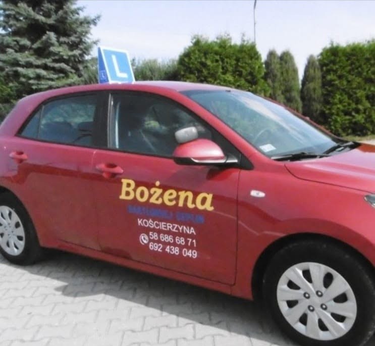 Czerwona KIA Rio szkoły jazdy Bożena z tabliczką L na dachu